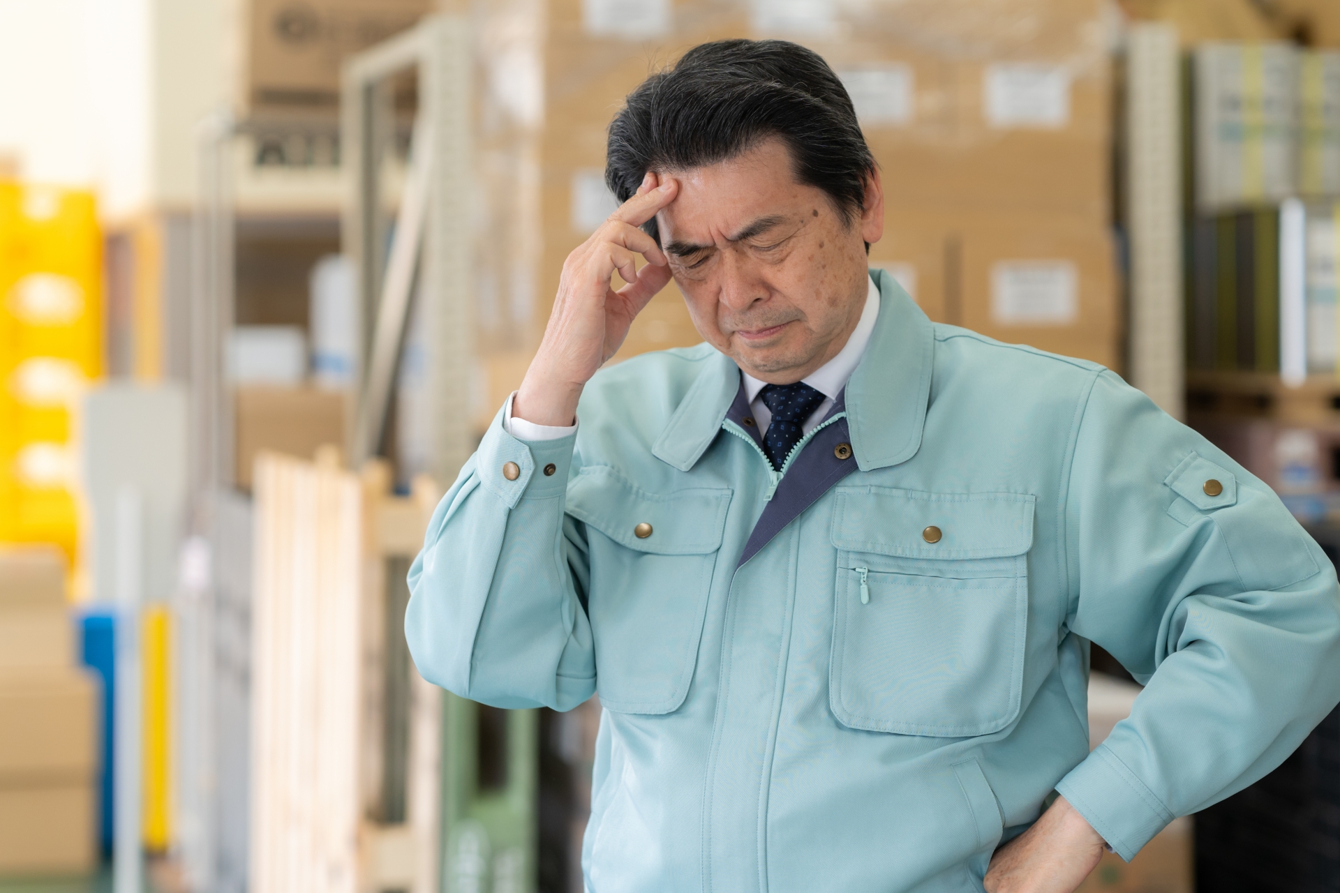 悩む作業着姿の男性