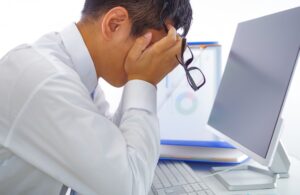 パソコン前で悩む男性